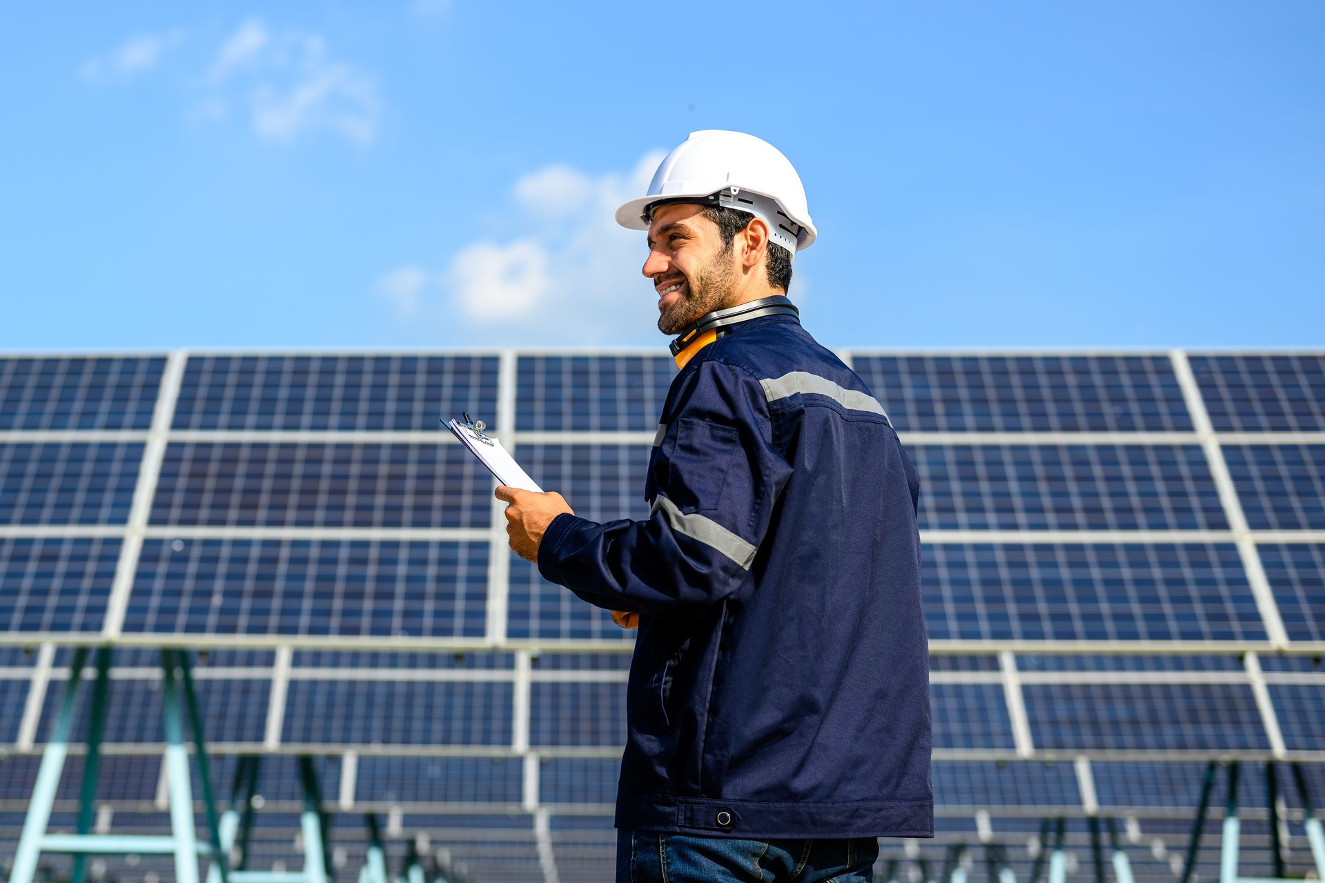Technician worker installing solar panels at solar cell farm